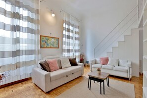 Una sala moderna con un sofá, una mesa de centro y una escalera.