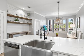 A modern kitchen with white cabinetry, a stainless steel sink, and a built-in dishwasher. - Luxurious 3 BR Condo overlooking 30A nestled between Rosemary & Alys Beach (Rosemary Beach)