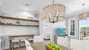 Eine moderne Küche mit weißen Schränken, Holz Arbeitsplatten und einem Essbereich mit einem Holztisch und Stühlen.