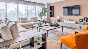 Una sala de estar moderna con un sofá, una mesa de centro y un sillón naranja.