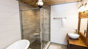 A modern bathroom with a glass-enclosed shower, a freestanding bathtub, and a wooden vanity with a mirror. - Bed & Breakfast in a 1795 Log Cabin on working farm, George Washington, Sr Suite (Swoope)