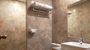 Un baño moderno con inodoro, lavamanos y toallero.