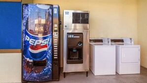 A vending machine with a Pepsi logo, an ice dispenser, and two washing machines. - Scottish Inn & Suites Houston Willowbrook (Houston)