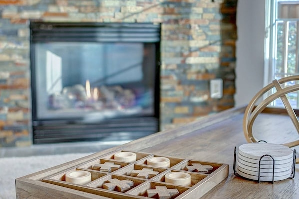 A wooden board game set on a table with a fireplace in the background. - Weekly Deals! Remodeled Retreat + Hot Tub + Garage (Steamboat Springs)
