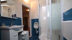 A bathroom with a shower, a urinal, a toilet, and a sink. - Apartments Bulic (Split)