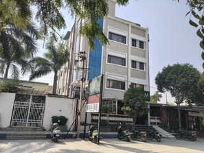 Ein mehrstöckiges Hotel mit einem Schild für 'Malibu The Brew House' und 'Hangout Restaurant'.