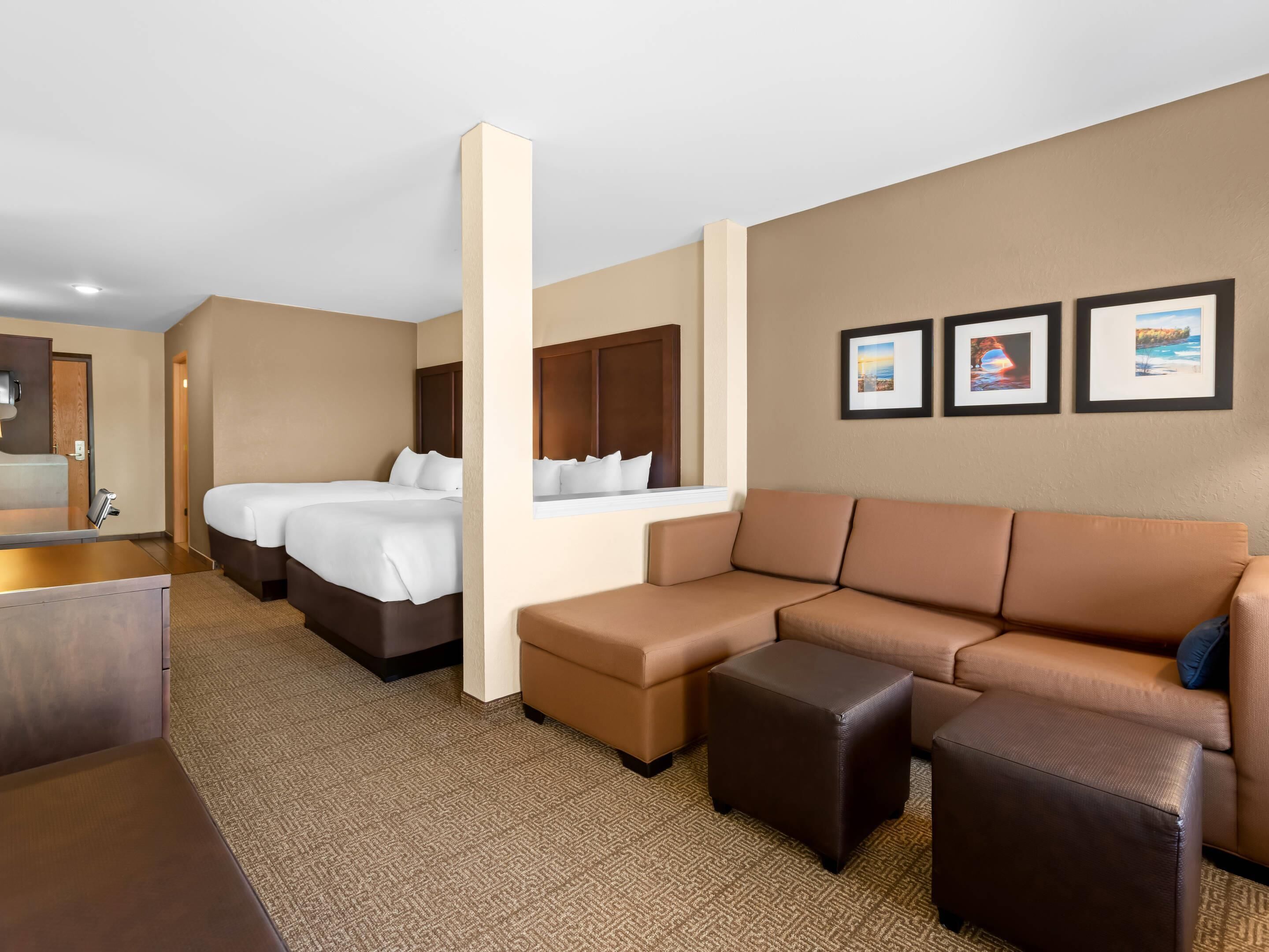 Una camera d'albergo con un letto, un divano, un tavolino da caffè e una scrivania.