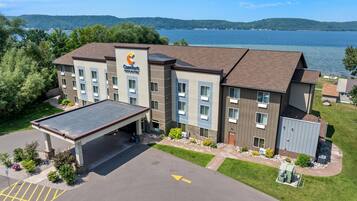 Een Comfort Inn hotel met een parkeerplaats, een overdekte ingang en uitzicht op een meer.