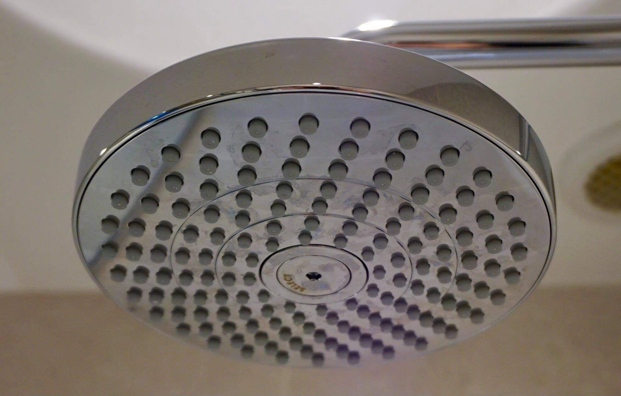 A showerhead with a circular design and multiple holes.