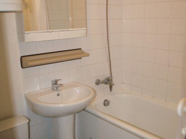 Un baño con lavabo, espejo y bañera.