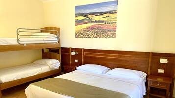 Ein Zimmer mit einem Etagenbett, einem Einzelbett, einem Nachttisch und einem Landschaftsbild.