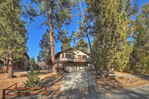 A two-story house with a covered front porch and a garage. - Cozy Bear Den by Destination Big Bear : 3 Bedroom, 2.5 Bath located in Prestigious Skyview Estates/Fox Farm! Outdoor Hot Tub! (Big Bear Lake)
