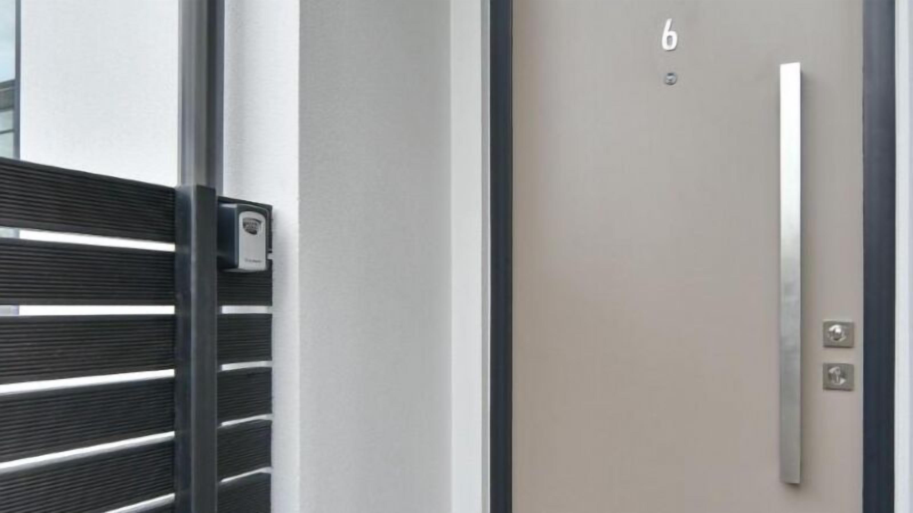 Een moderne deur met een metalen handgreep en het nummer '6', wat de kamer aangeeft.