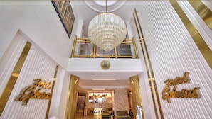 Zona reception di un hotel con un lampadario, una scrivania della reception e un cartello che recita 'Hotel Ephesus'.