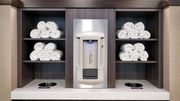 Ein Handtuchstation mit integriertem Handtuchwärmer, zwei Handtuchhaltern und einem Waschbecken.