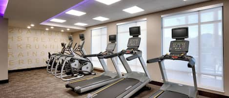 Een sportschool met loopbanden, hometrainers en elliptische trainers.