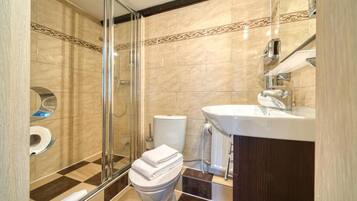 A modern bathroom with a glass shower enclosure, a toilet, and a sink.