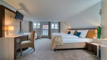 A hotel room with a bed, a desk, a chair, a TV, and a window.