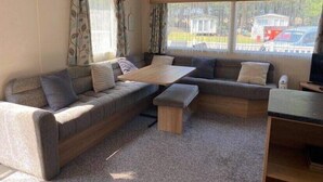 Un salon confortable avec un canapé, une table basse en bois et un téléviseur.