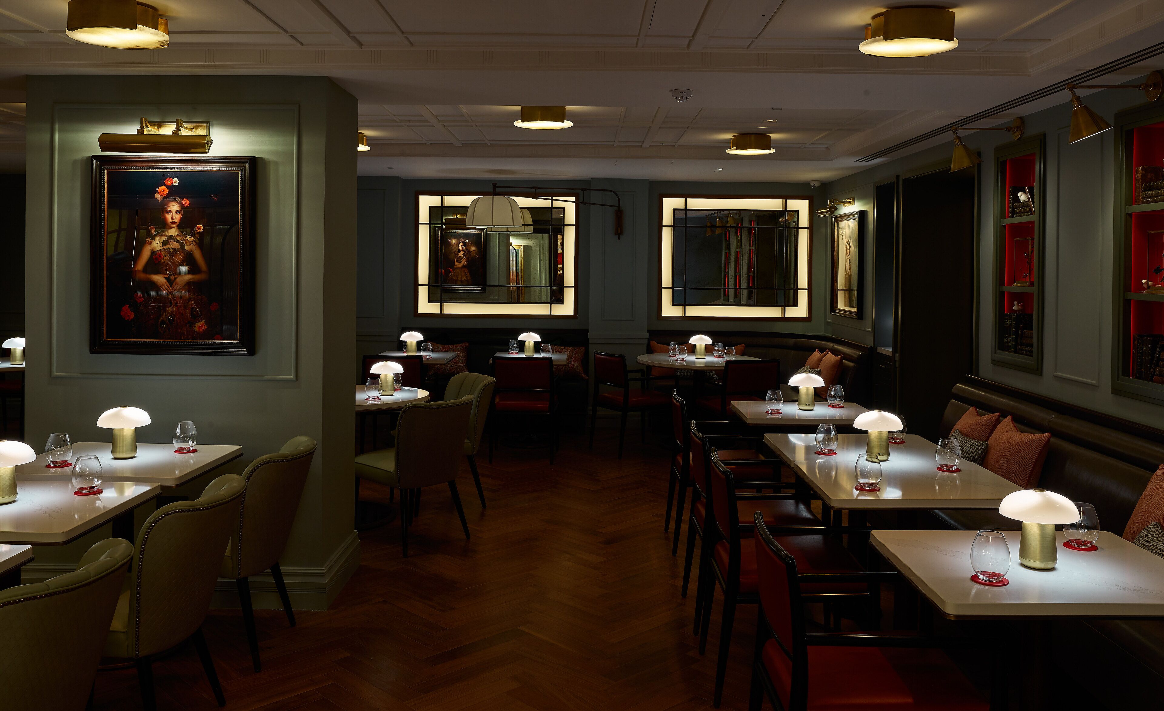 A restaurant with multiple tables and chairs, each with a table lamp.