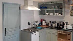 A compact kitchen with a built-in dishwasher, a coffee maker, and a microwave.