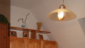 A bedroom with a wooden bed, a nightstand, a lamp, and a shelf with framed photos. - 5-bed apartment with superb view of Lake Artouste (Laruns)