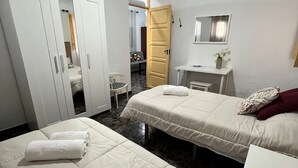 A hotel room with two beds, a wardrobe, a desk, and a mirror. - Holiday Home Casa del Molino with Sea & Mountain Views, Wi-Fi, and Terrace (Icod de los Vinos)