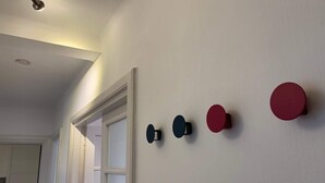 Un corridoio con una porta bianca e un muro bianco decorato con elementi circolari.