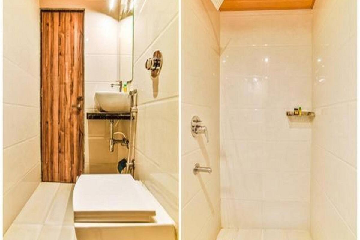 A bathroom with a wooden door, a sink, and a shower area.