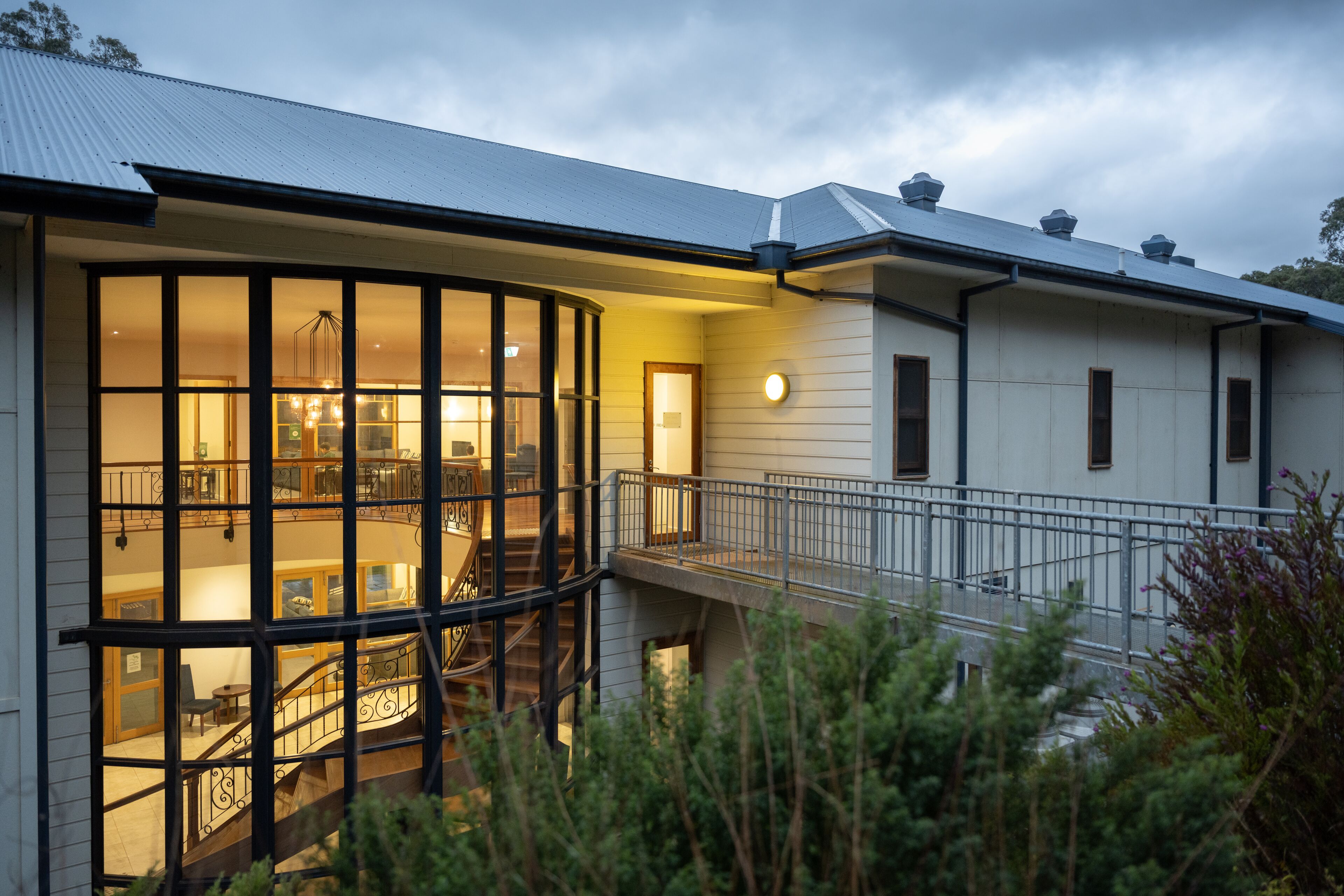 A modern house with large windows, a staircase, and a balcony.