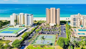 A high-rise hotel with multiple floors, a tennis court, and a parking lot. - Beachfront 2 Bed at Popular Seawinds! (Marco Island)