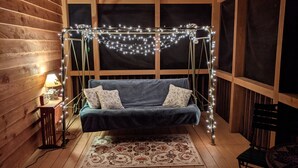 A cozy room with a blue sofa, a small table with a lamp, and a decorative string of lights.