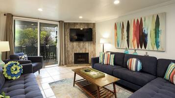 A modern living room with a sofa, a coffee table, and a TV mounted on a wall.