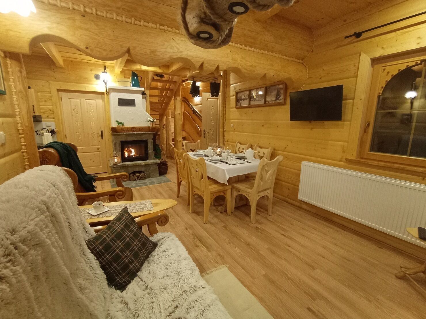 L’intérieur d’un chalet confortable, avec une salle à manger, une cheminée et des murs en bois.