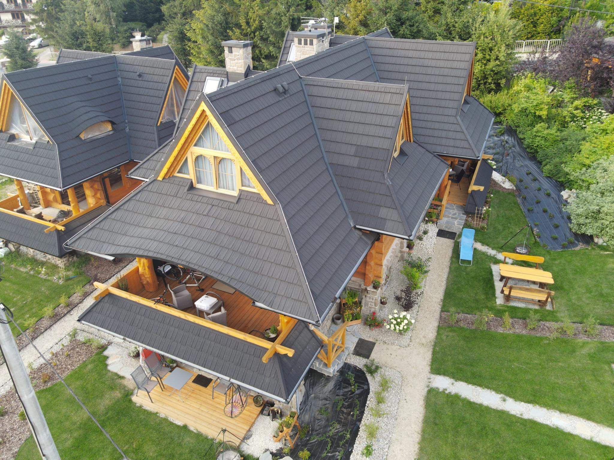 Une maison à plusieurs étages, dotée d’un grenier bien visible et d’une grande terrasse.