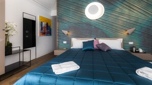Ein modernes Hotelzimmer mit einem großen Bett, einer wandmontierten runden Lampe und einem Gemälde.