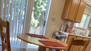 A dining area with a round table, four wooden chairs, and a patterned rug. - Basics 90's Condo 906 Downtown Moses Lake (Moses Lake)