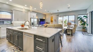 A modern kitchen with a large island, white cabinetry, and pendant lighting. - 4 bdrm house close to restaurants, beach, attractions and quick boating access (Cape Coral)