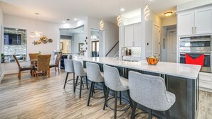 A modern kitchen with a large island, bar stools, and a built-in oven. - 4 bdrm house close to restaurants, beach, attractions and quick boating access (Cape Coral)