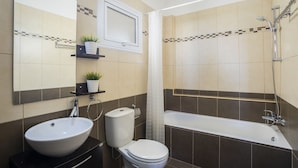 Ein modernes Badezimmer mit Doppelwaschbecken, Toilette und Badewanne.