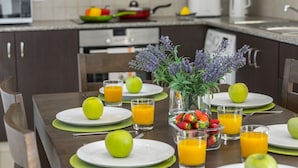 Ein Frühstückstisch mit Fruchtschalen, Orangensaftgläsern und einer Blumenvase.