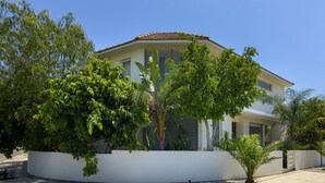 Ein modernes, zweistöckiges Haus mit weißer Fassade, großen Fenstern und einem Ziegeldach.