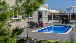 A rooftop pool area with a pool, lounge chairs, and outdoor furniture. - Your Dream 5-star Escape: Protaras Villa 1483 (Paralimni)