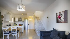 Un espace de vie moderne comprenant un coin repas, une cuisine et un escalier.