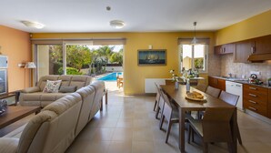 A spacious living area with a sofa, dining table, and kitchen. - At Last You can Rent the Perfect Luxury Villa in Larnaca, Larnaca Villa 1392 (Pervolia)