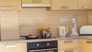 Eine Küche mit Backofen, Kochfeld, Wasserkocher und Mixer.