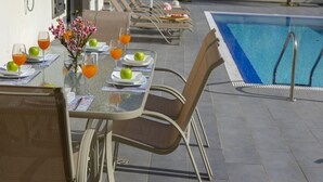 A poolside dining area with tables set for two, equipped with plates, glasses, and cutlery. - Rent Your 5-star Villa With Private Pool Protaras Villa 1525 (Paralimni)