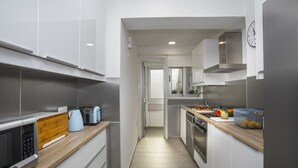 A narrow kitchen with white cabinets, a microwave, a toaster, and a sink. - Fall in Love With This Luxury Beachfront 1386 (Larnaca)
