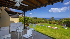 A covered patio with white furniture, a ceiling fan, and a view of the ocean. - Seaside Serenity: Protaras Villa 1515 (Paralimni)