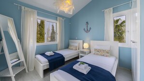 A room with two beds, a white wardrobe, a small table, and a hanging light fixture. - Your Beautiful Holiday Villa Minutes From the Beach, Protaras Villa 1492 (Paralimni)